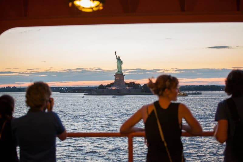 一名女子在前往纽约的单人旅行中，从史坦顿岛渡轮上欣赏自由女神像