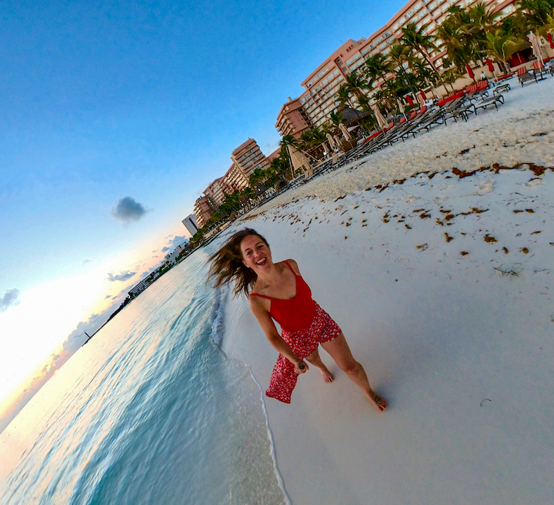 女性旅游博主在bob游戏app手机下载bobapp网页版墨西哥坎昆的海滩上跑步