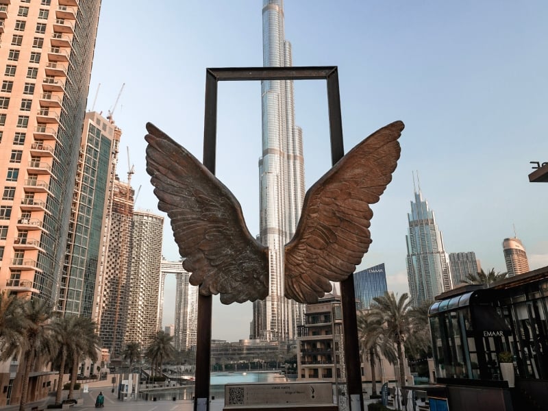 一名女子独自前往迪拜，在哈利法塔前观看蝴蝶雕塑
