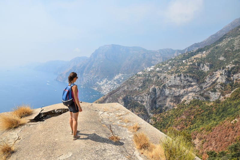 一名女子独自在意大利旅行，沿着阿马尔菲海岸徒步旅行众神之路